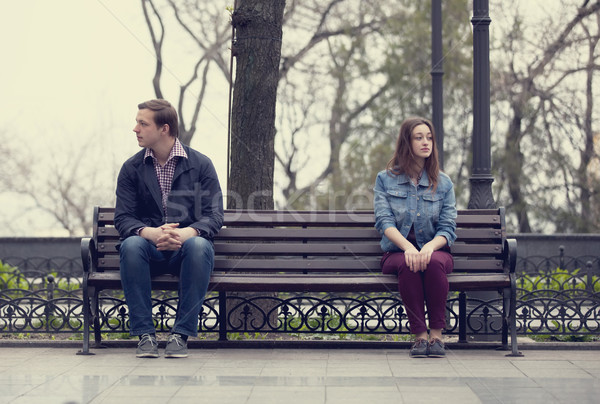 Sad teens sitting at the bench at the park Stock photo © Massonforstock