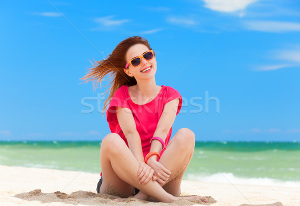 Funny teen girl sitting on the sand at the beach. Stock photo © Massonforstock