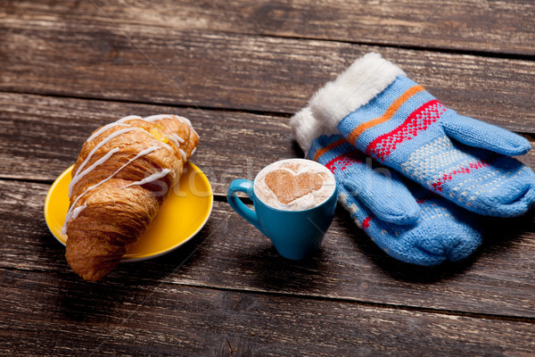 photo of delicious fresh croissant, cup of coffee and warm glove Stock photo © Massonforstock