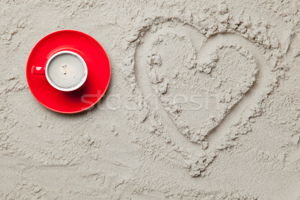 photo of heart shaped drawing and cup of coffee on the sand on t Stock photo © Massonforstock