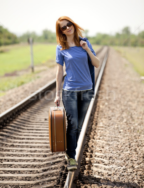 Stock photo: Young fashion girl with suitcase at railways.