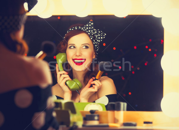 Stock photo: woman with dial phone applying cosmetics