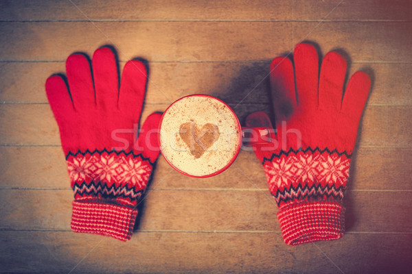 Stock photo: photo of cup of coffee and warm gloves on the wonderful brown wo