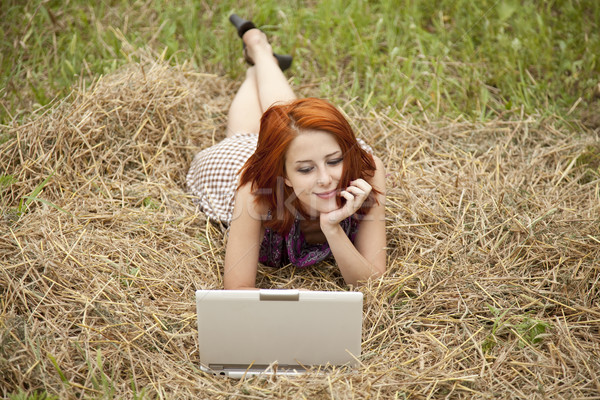 Stock photo: Young  fashion girl with notebook lying at field
