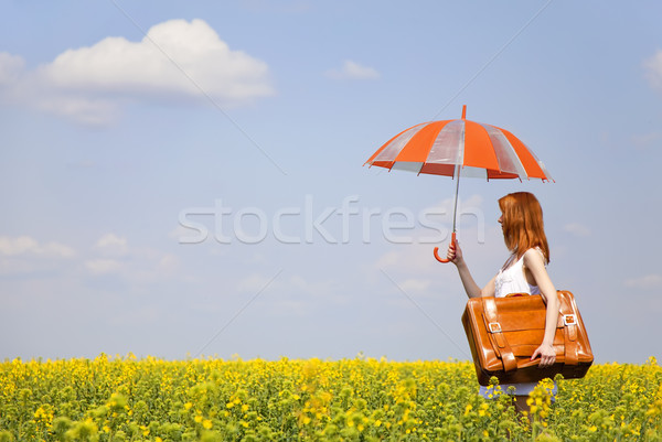 Stock photo: Redhead enchantress with umbrella and suitcase at spring rapesee