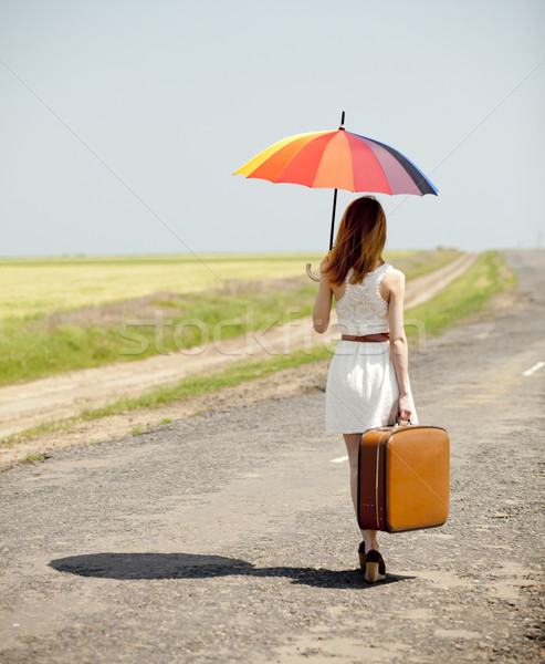 Young fashion girl with umbrella and suitcase at spring outdoor. Stock photo © Massonforstock