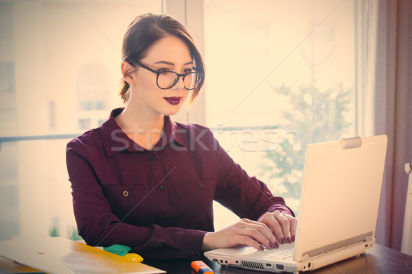 beautiful young woman sitting at the desk and working with lapto Stock photo © Massonforstock