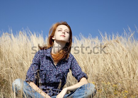 Portrait of happy red-haired girl on autumn grass. Stock photo © Massonforstock