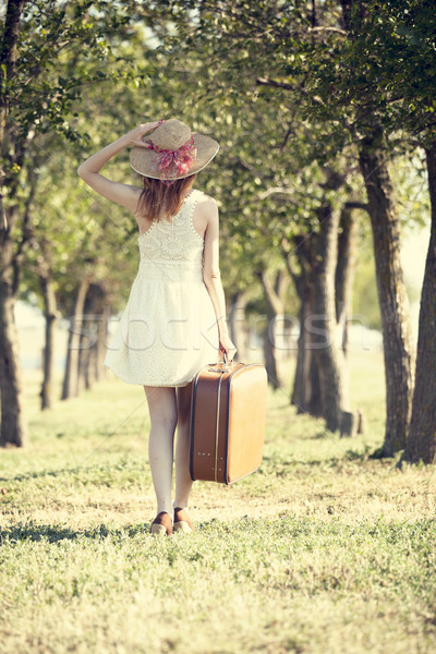 Redhead girl with suitcase at tree's alley. Stock photo © Massonforstock