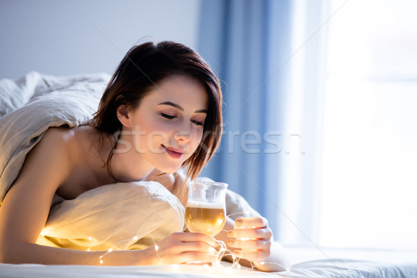 Beautiful rednead woman with cup of coffee or cappuccino in a be Stock photo © Massonforstock