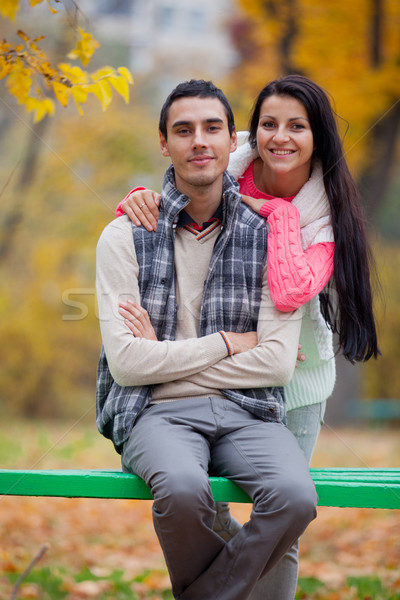 photo of cute couple sitting on the bench on the wonderful autum Stock photo © Massonforstock