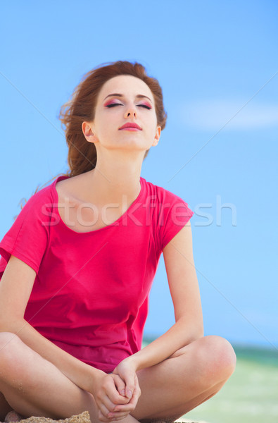 Funny teen girl sitting on the sand at the beach. Stock photo © Massonforstock