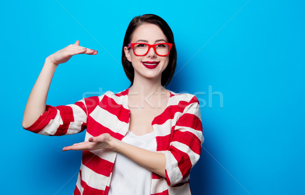 portrait of the beautiful young smiling woman on the blue backgr Stock photo © Massonforstock