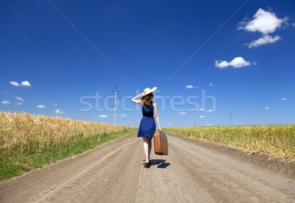 Lonely girl with suitcase at country road.  Stock photo © Massonforstock