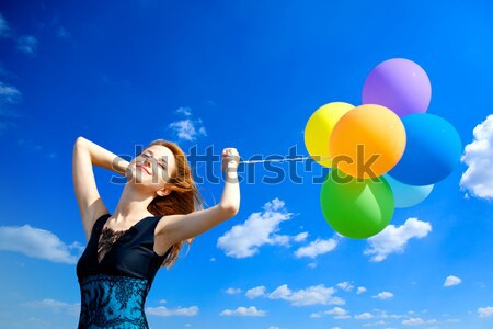 Redhead girl with colour balloons at blue sky background.  Stock photo © Massonforstock