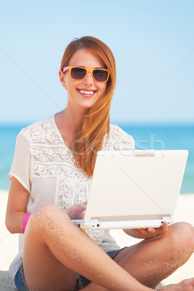 Cute woman with white laptop on the summer beach Stock photo © Massonforstock