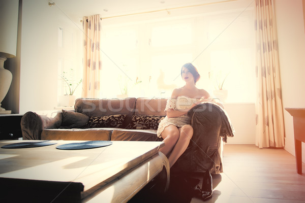 beautiful young woman sitting on the sofa in the light luxury ro Stock photo © Massonforstock