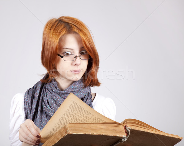 Stock photo: Young doubting fashion girl in glasses with old book