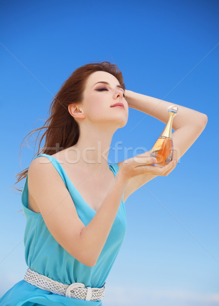 Redhead girl with perfume on the beach Stock photo © Massonforstock