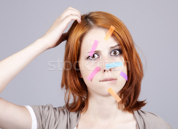 Confused red-haired businesswomen with notes on face. Stock photo © Massonforstock