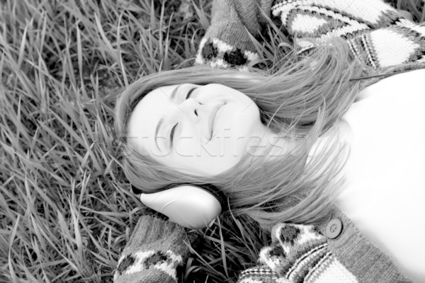 Young fashion girl with headphones lying at grass. Photo in blac Stock photo © Massonforstock