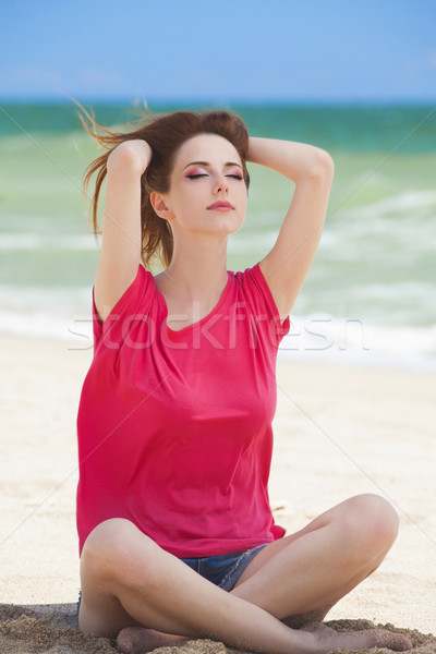 Funny teen girl sitting on the sand at the beach. Stock photo © Massonforstock