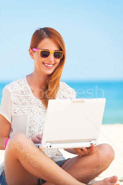 Cute woman with white laptop on the summer beach Stock photo © Massonforstock