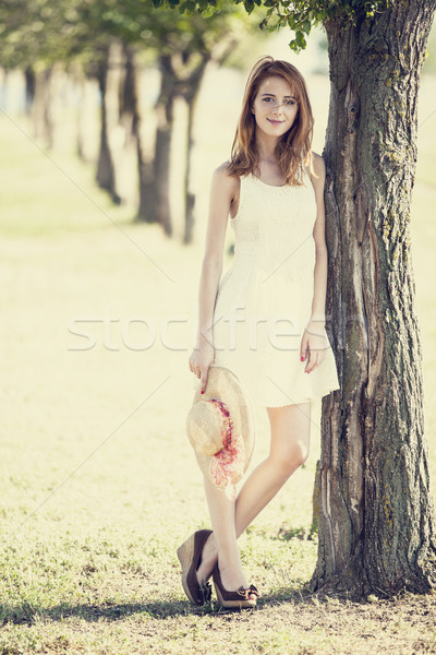 Redhead girl with hat near tree. Stock photo © Massonforstock