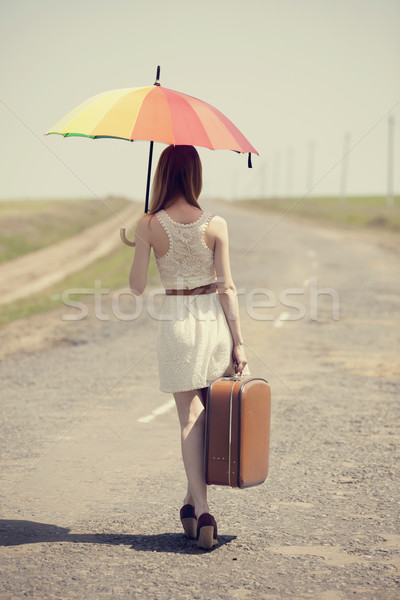 Redhead enchantress walking near rapeseed field. Photo in old im Stock photo © Massonforstock