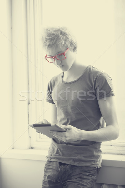 Hipster boy with tablet near window. Photo with a little noise Stock photo © Massonforstock