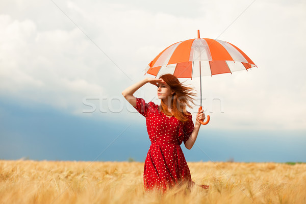 Redhead girl with umbrella at field Stock photo © Massonforstock