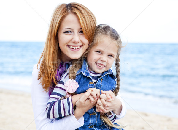 Two sisters 5 and 22 years old at the beach in sunny autumn day Stock photo © Massonforstock