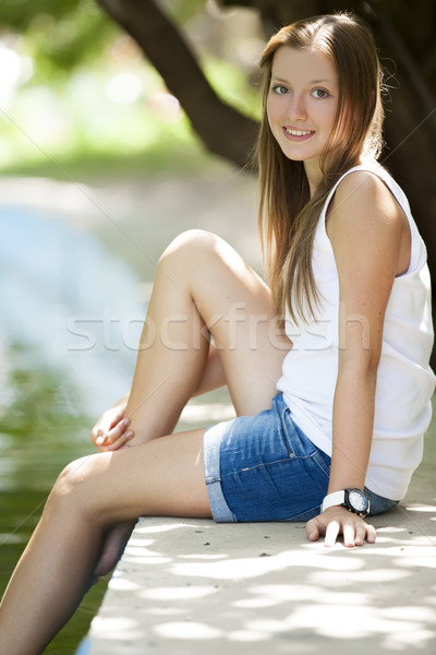 Stock photo: Teen girl near lake in the park.