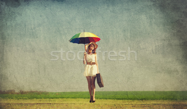 Stock photo: Redhead enchantress with umbrella and suitcase at spring country