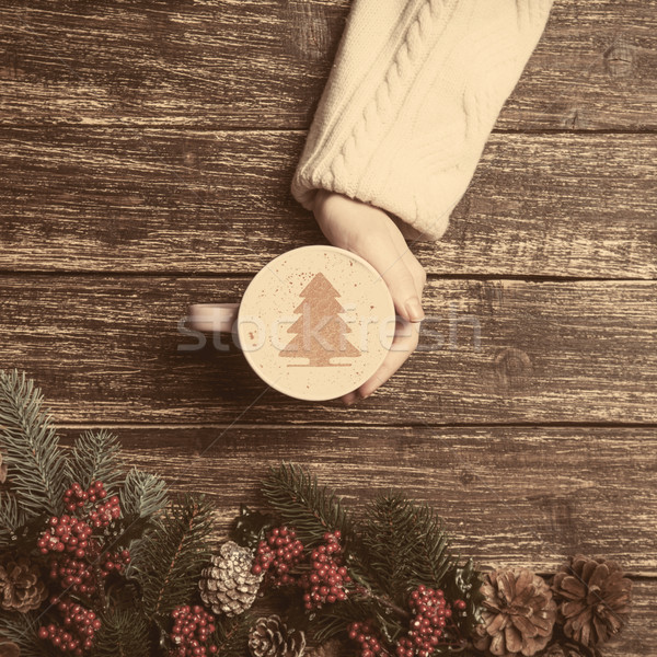 Female holding cup of coffee with cream christmas tree on a tabl Stock photo © Massonforstock