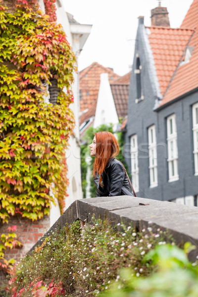 beautiful young woman standing near the stone fence and explorin Stock photo © Massonforstock