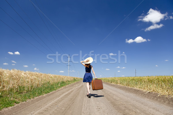 Magányos lány bőrönd vidéki út út nők Stock fotó © Massonforstock