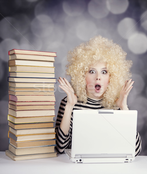 Stock photo: Funny girl in wig with notebook and books. Studio shot.