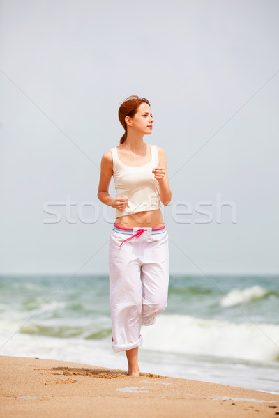 Healthy woman running on the beach Stock photo © Massonforstock