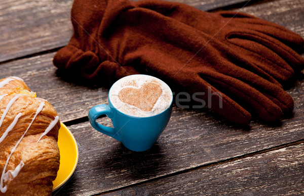 photo of delicious fresh croissant, cup of coffee and warm glove Stock photo © Massonforstock