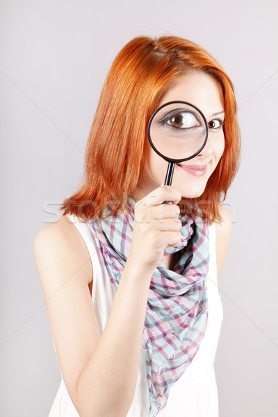 Beautiful red-haired girl with loupe zooming her eye. Stock photo © Massonforstock