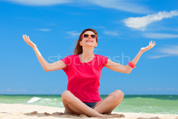 Funny teen girl sitting on the sand at the beach. Stock photo © Massonforstock