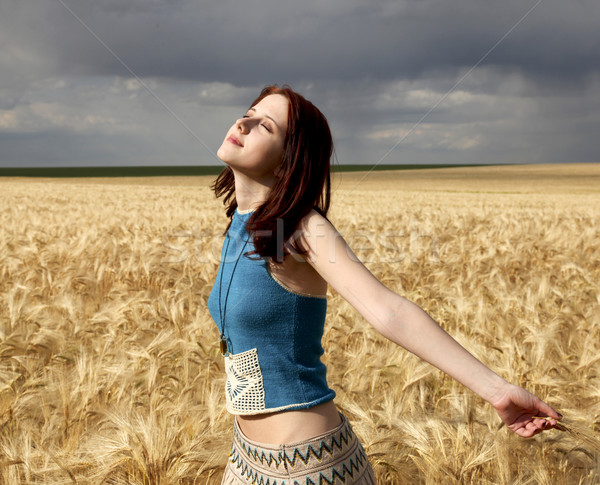 Stock photo: Girl at wheat field in storm day.