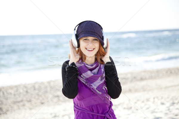 Stock photo: Portrait of red-haired girl with headphone on the beach.