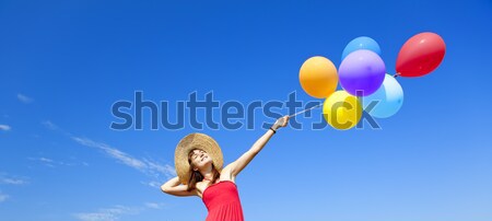 Stock photo: Redhead girl with colour balloons at blue sky background. 