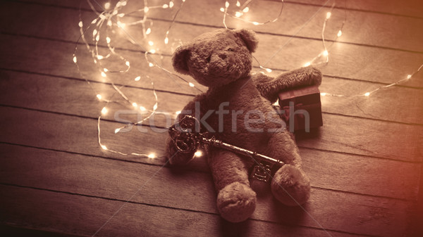 cute fluffy teddy bear with gift and golden key and bright garla Stock photo © Massonforstock