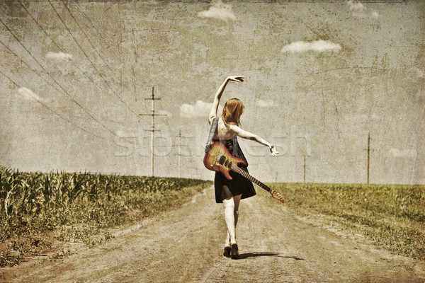 Rock girl with guitar at countryside. Photo in old image style. Stock photo © Massonforstock