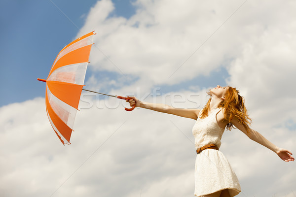 Girl with umbrella at sky background. Stock photo © Massonforstock