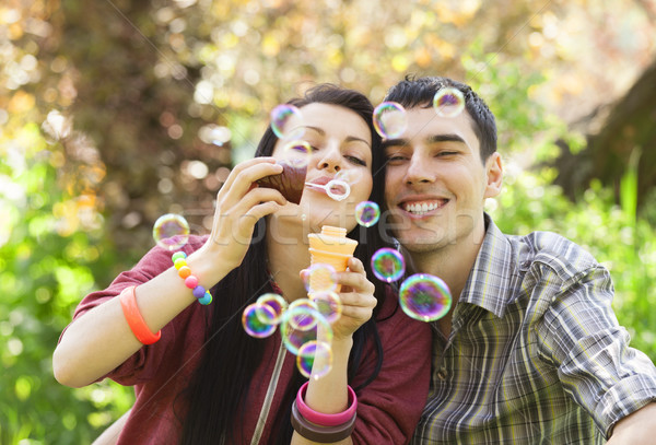 Couple Relaxing in the Park with bubble blower Stock photo © Massonforstock