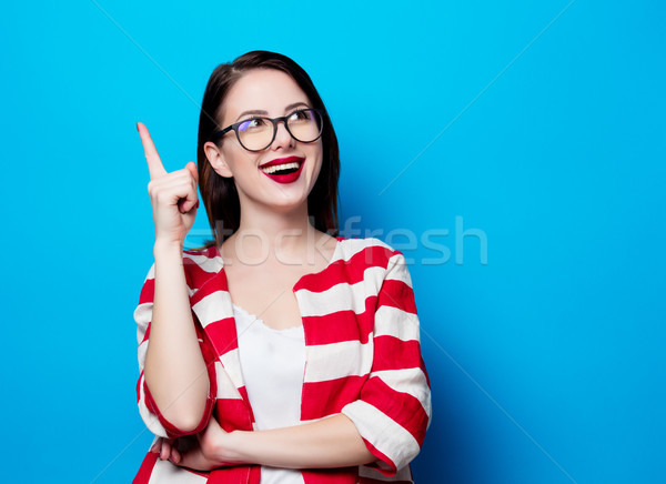 portrait of the beautiful young smiling woman on the blue backgr Stock photo © Massonforstock